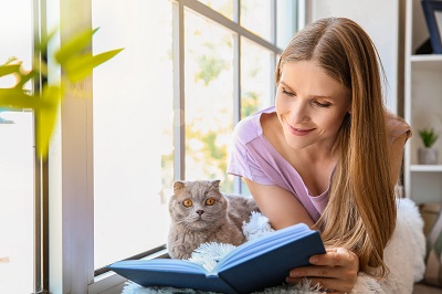猫と一緒に本を読む女性